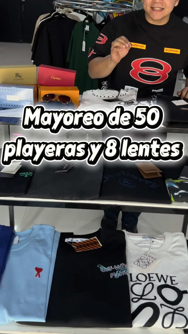 Pedido de mayoreo de 50 playeras y 8 lentes acomodado sobre la mesa de la tienda
